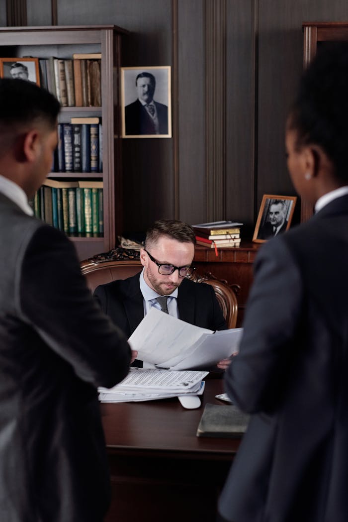 mobile-01 Business professionals discussing important legal documents in an office setting.